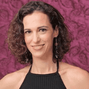 White woman with dark hair wearing a sleeveless top faces the camera smiling